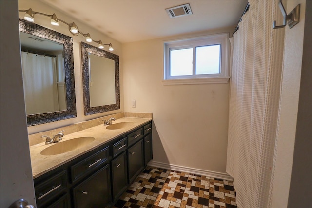 bathroom with baseboards and double vanity