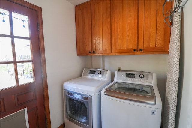washroom featuring independent washer and dryer and cabinet space