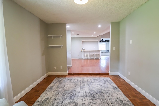 unfurnished room with baseboards and a textured ceiling