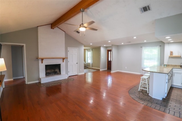 unfurnished living room featuring a ceiling fan, a brick fireplace, wood finished floors, healthy amount of natural light, and recessed lighting