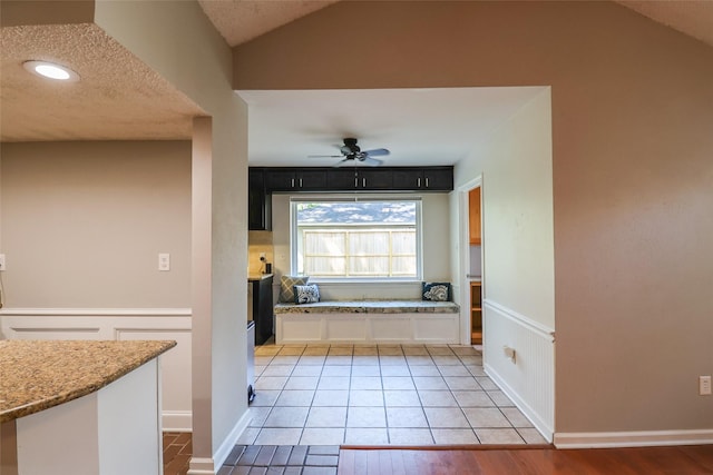 kitchen featuring a ceiling fan, light stone counters, white cabinetry, lofted ceiling, and recessed lighting