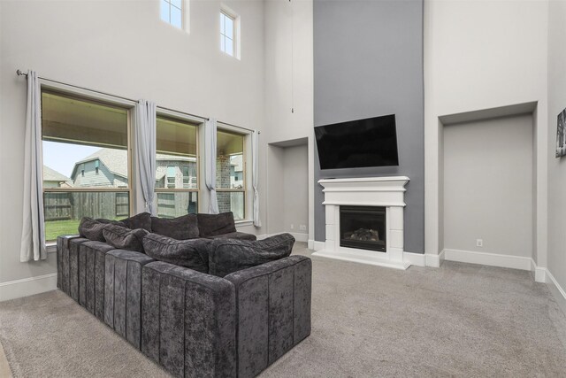 12510 Grayton Dr, Texas City, TX 77568 - carpeted living room featuring a towering ceiling, a fireplace with raised hearth, and baseboards