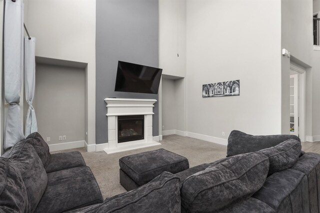 12510 Grayton Dr, Texas City, TX 77568 - living area featuring a towering ceiling, carpet floors, baseboards, and a glass covered fireplace