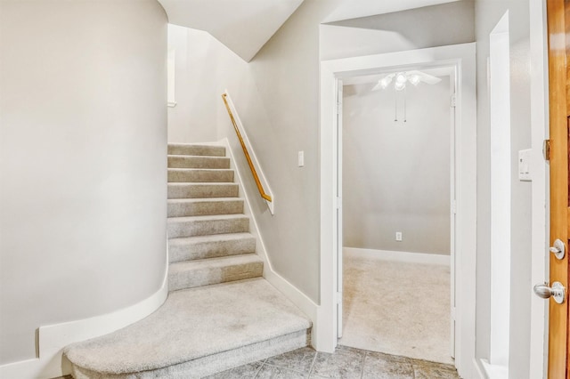 stairway featuring carpet floors, ceiling fan, vaulted ceiling, and baseboards