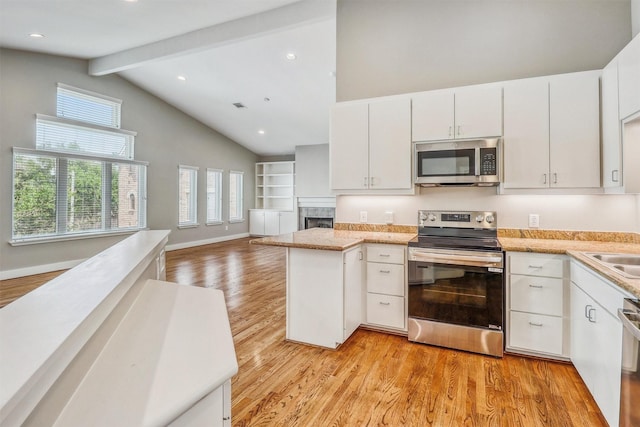 kitchen featuring stainless steel appliances, light wood-type flooring, beam ceiling, white cabinets, and open floor plan