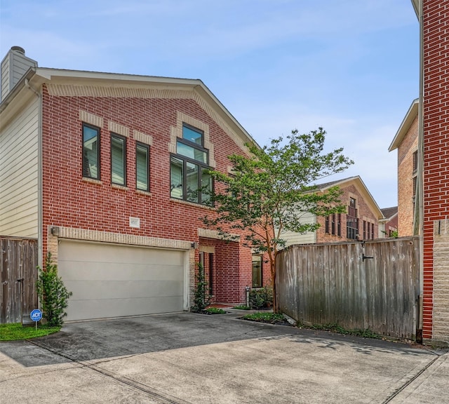 view of front of home with a garage, driveway, and brick siding
