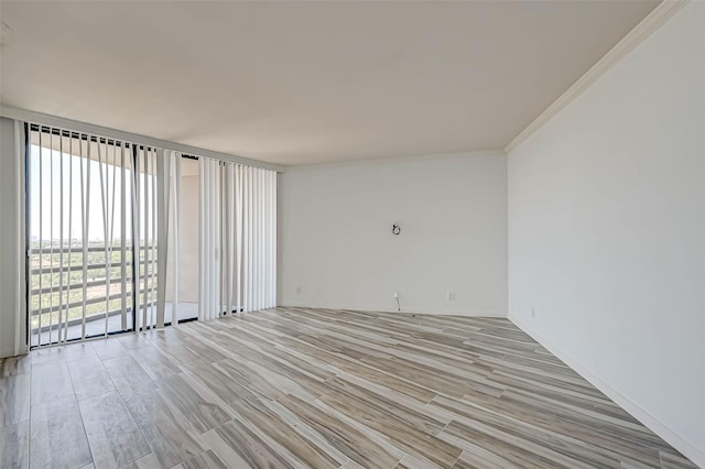 spare room featuring wood finish floors and ornamental molding