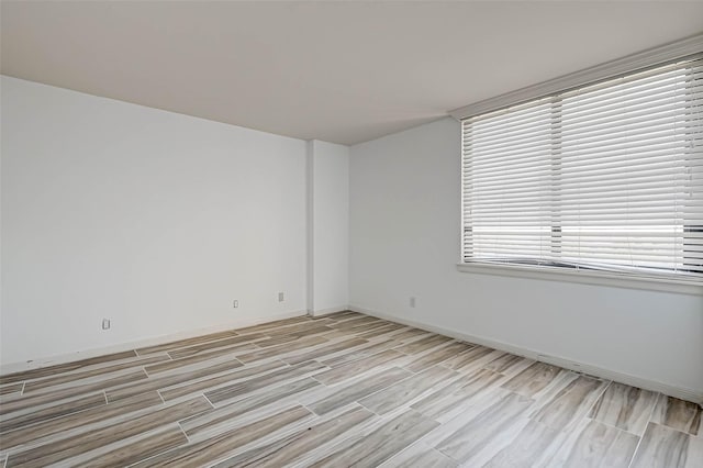 unfurnished room with light wood finished floors and baseboards