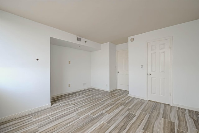 spare room with light wood-style flooring and baseboards