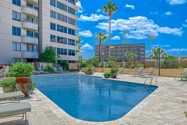 community pool featuring fence and a patio