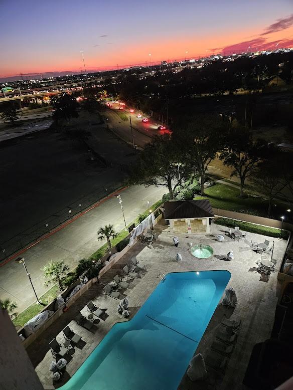 pool at dusk featuring a gazebo, a community pool, and a patio area