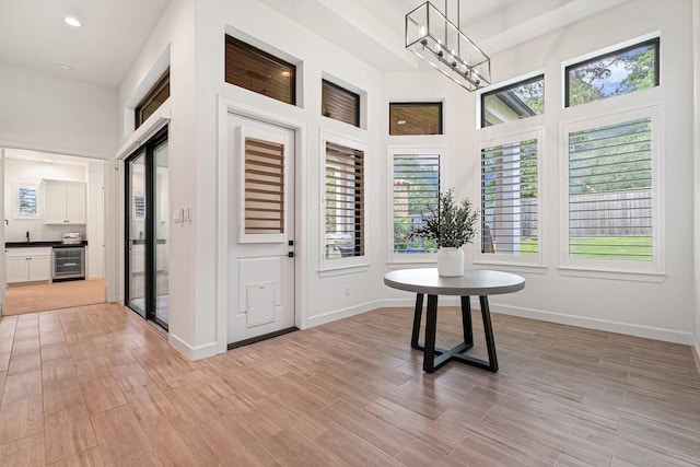 1703 Madera Oaks Ct, Conroe, TX 77304 - hallway featuring wine cooler, a chandelier, plenty of natural light, light wood-style floors, and recessed lighting