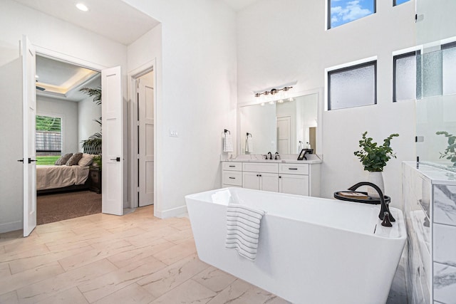 1703 Madera Oaks Ct, Conroe, TX 77304 - bathroom featuring a freestanding bath, connected bathroom, vanity, marble look tile flooring, and a towering ceiling