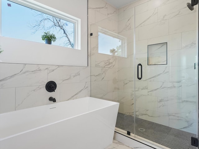 930 Mansfield St, Houston, TX 77091 - bathroom with marble look tiles, a shower stall, and a freestanding tub
