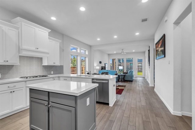 11822 Radura Rd, Humble, TX 77346 - kitchen with stainless steel appliances, a center island, a sink, gray cabinetry, and light countertops
