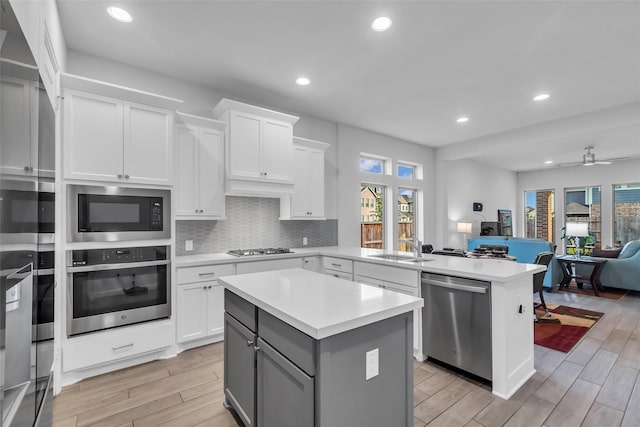11822 Radura Rd, Humble, TX 77346 - kitchen with stainless steel appliances, open floor plan, light countertops, light wood-style floors, and healthy amount of natural light