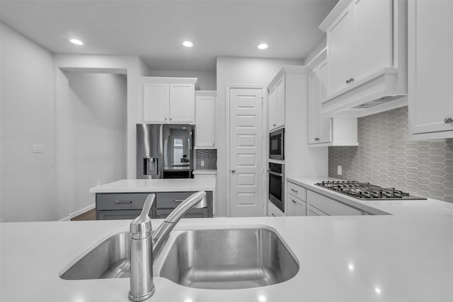 11822 Radura Rd, Humble, TX 77346 - kitchen featuring stainless steel appliances, a sink, light countertops, white cabinetry, and recessed lighting