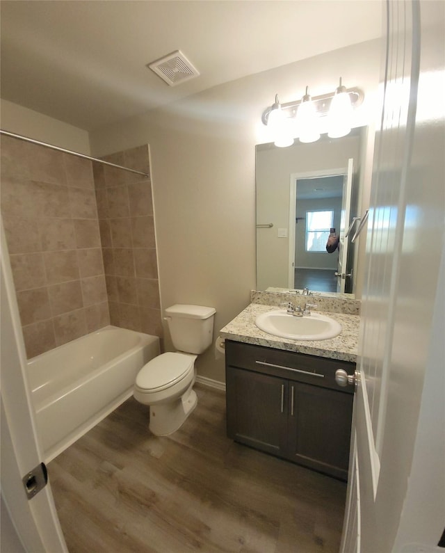 419 8th Ave N, Texas City, TX 77590 - bathroom featuring wood finished floors, toilet, vanity, baseboards, and shower / bathtub combination