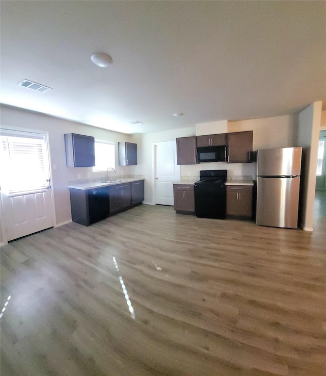 419 8th Ave N, Texas City, TX 77590 - kitchen with black appliances, light countertops, wood finished floors, and a sink