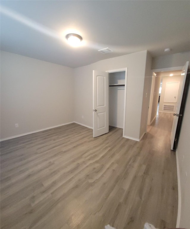 419 8th Ave N, Texas City, TX 77590 - unfurnished bedroom featuring wood finished floors, baseboards, and a closet