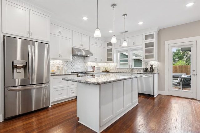 2714 Gano St, Houston, TX 77009 - kitchen featuring appliances with stainless steel finishes, under cabinet range hood, dark wood finished floors, a sink, and white cabinetry