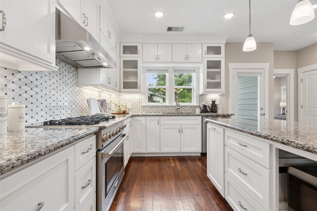 2714 Gano St, Houston, TX 77009 - kitchen with under cabinet range hood, high end stainless steel range, a sink, white cabinets, and recessed lighting