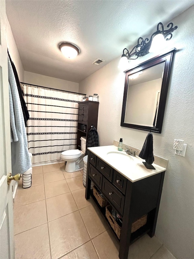 bathroom featuring a textured ceiling, toilet, vanity, tile patterned floors, and a shower with curtain