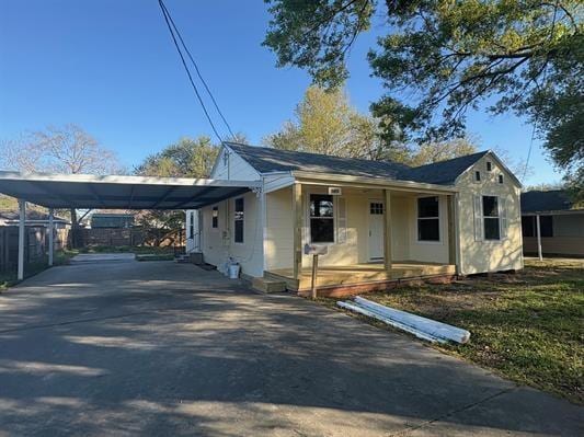 6240 25th St, Groves, TX 77619 - view of front facade featuring driveway, an attached carport, and a porch