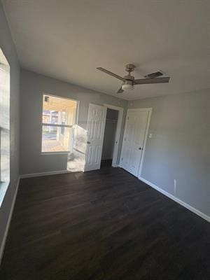 6240 25th St, Groves, TX 77619 - unfurnished bedroom featuring baseboards, multiple windows, and dark wood finished floors