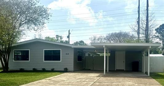 612 S 15th St, Nederland, TX 77627 - back of property featuring driveway, a carport, and a lawn