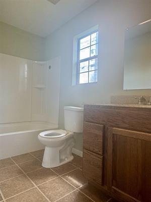 612 S 15th St, Nederland, TX 77627 - full bathroom featuring toilet, tile patterned flooring, vanity, and washtub / shower combination