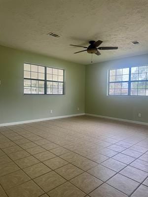 612 S 15th St, Nederland, TX 77627 - empty room featuring plenty of natural light, baseboards, a ceiling fan, and tile patterned floors