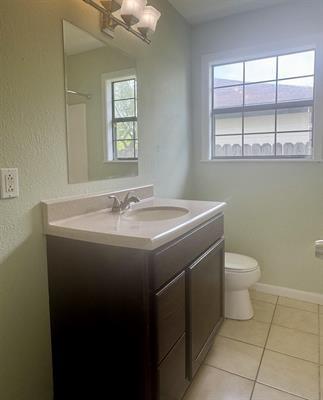 612 S 15th St, Nederland, TX 77627 - bathroom featuring toilet, vanity, tile patterned floors, and baseboards
