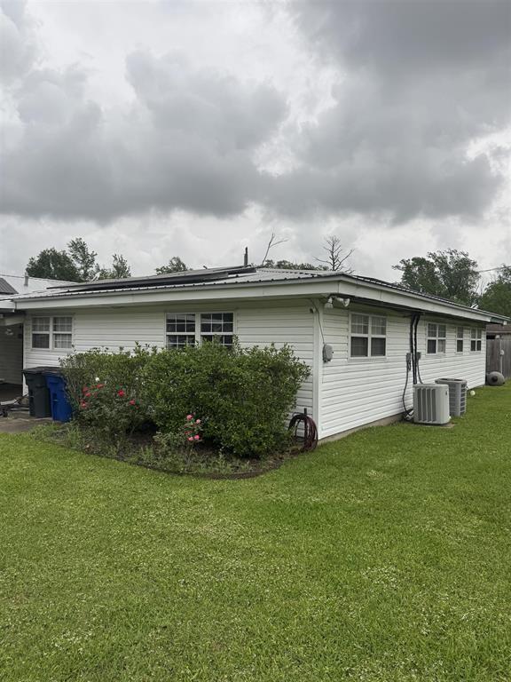 401 Henry St, Bridge City, TX 77611 - rear view of house with a lawn