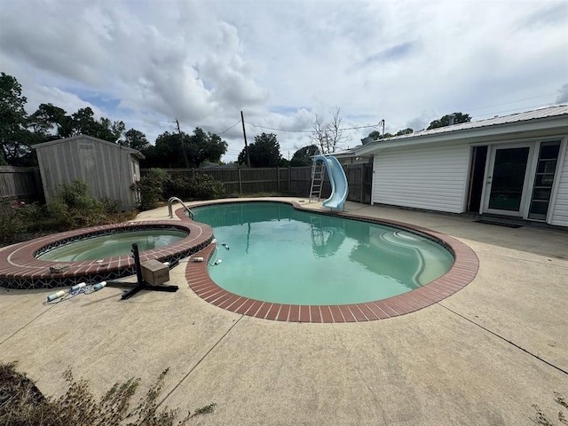 401 Henry St, Bridge City, TX 77611 - view of swimming pool featuring a water slide, a shed, a fenced backyard, a patio, and an outbuilding