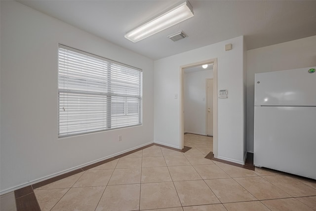 spare room with light tile patterned floors and baseboards