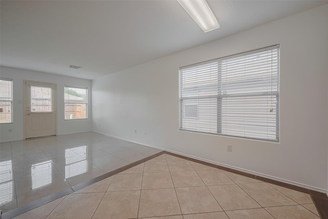 unfurnished room with light tile patterned floors and baseboards