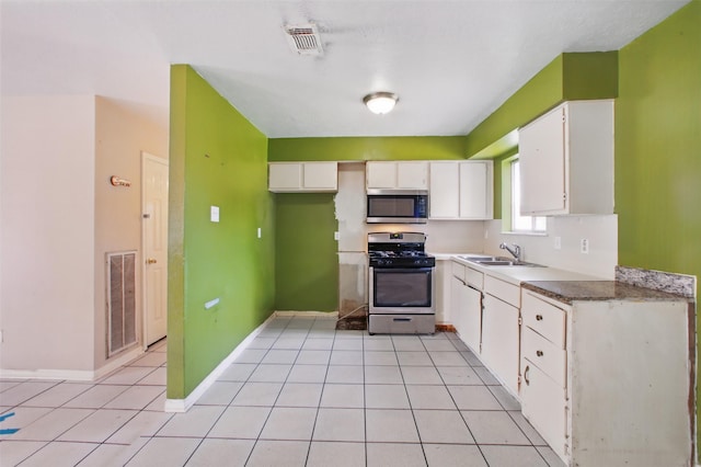 1911 Thonig Rd, Houston, TX 77055 - kitchen featuring appliances with stainless steel finishes, a sink, white cabinets, and light tile patterned flooring