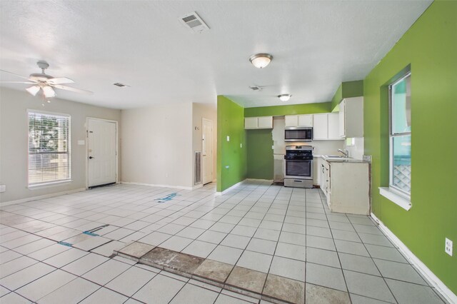 1911 Thonig Rd, Houston, TX 77055 - kitchen with stainless steel appliances, white cabinetry, ceiling fan, a sink, and light tile patterned flooring