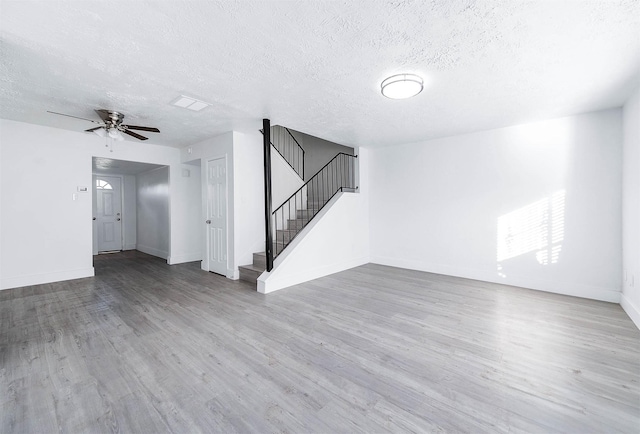 7109 Chasewood Dr, Houston, TX 77489 - unfurnished living room with stairway, a textured ceiling, a ceiling fan, wood finished floors, and baseboards
