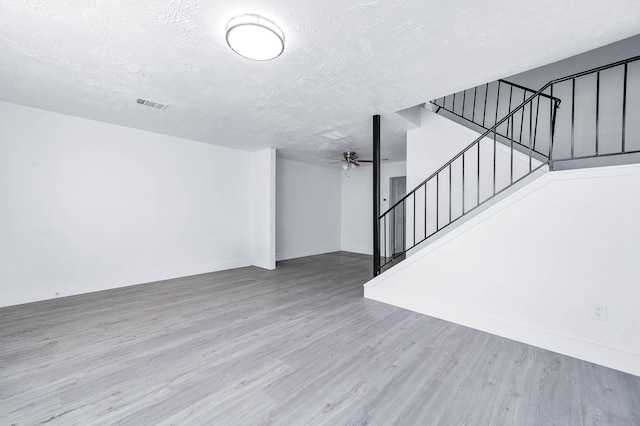7109 Chasewood Dr, Houston, TX 77489 - unfurnished living room with stairs, a textured ceiling, wood finished floors, a ceiling fan, and baseboards