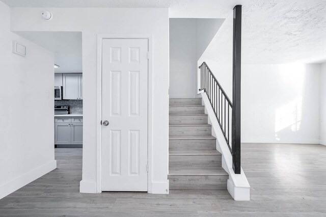 7109 Chasewood Dr, Houston, TX 77489 - stairway featuring wood finished floors, baseboards, and a textured ceiling