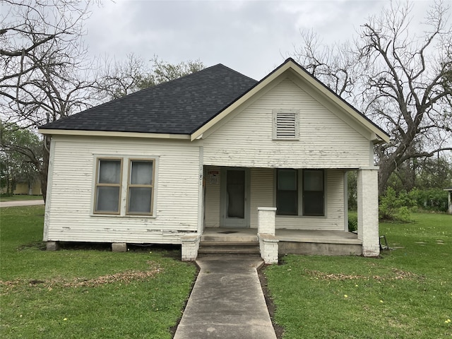 1401 8th St, Bay City, TX 77414 - view of front facade with a porch, a shingled roof, and a front lawn