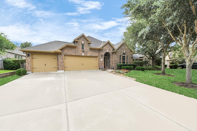 419 Sunny River Ln, Richmond, TX 77406 - view of front facade with brick siding, an attached garage, driveway, and roof with shingles