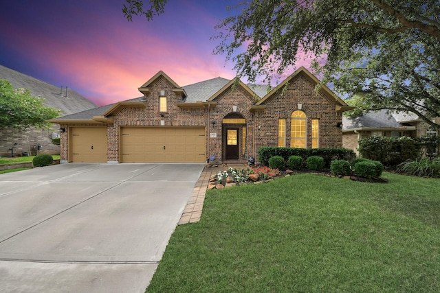 419 Sunny River Ln, Richmond, TX 77406 - french country inspired facade featuring brick siding, a front lawn, a garage, driveway, and a shingled roof