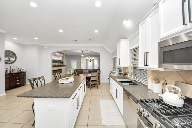 419 Sunny River Ln, Richmond, TX 77406 - kitchen featuring a sink, appliances with stainless steel finishes, arched walkways, decorative backsplash, and recessed lighting