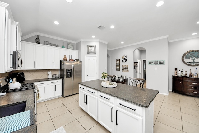 419 Sunny River Ln, Richmond, TX 77406 - kitchen featuring appliances with stainless steel finishes, arched walkways, light tile patterned floors, recessed lighting, and tasteful backsplash
