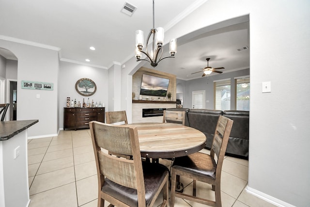 419 Sunny River Ln, Richmond, TX 77406 - dining area with a ceiling fan, a large fireplace, light tile patterned floors, crown molding, and a chandelier
