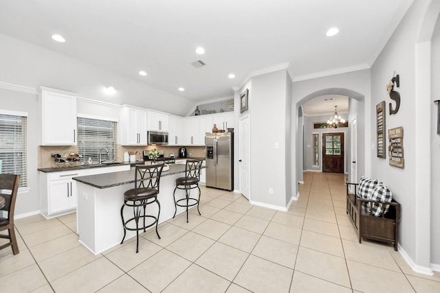 419 Sunny River Ln, Richmond, TX 77406 - kitchen featuring stainless steel appliances, arched walkways, a breakfast bar, crown molding, and a center island