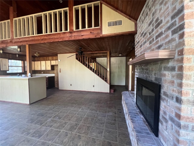 101 Hidden Cove Dr, Point Blank, TX 77364 - unfurnished living room with wooden ceiling, a fireplace, wooden walls, a ceiling fan, and stairway